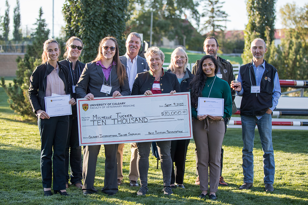 WCVM PhD student Dr. Michelle Tucker (centre) holding large cheque for $10,000