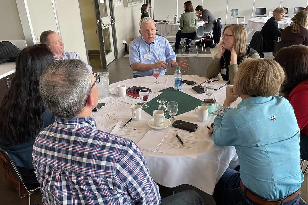 Scientist speaking to a group of people at table