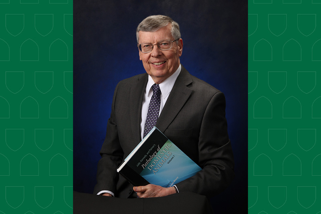 Dr. Grant Maxie holding a copy of his textbook.
