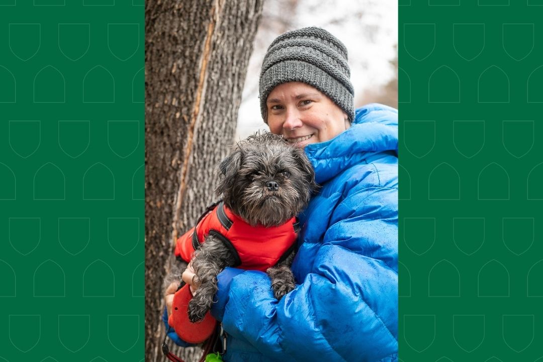 Griffyn the dog, held by its owner - a woman in a blue coat.